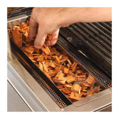Lifesytle picture of adding smoking chips in a Blaze smoker box. Model is BLZ-SMBX.
